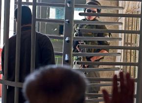 An Israeli soldier watches Palestinians passing through a West Bank checkpoint